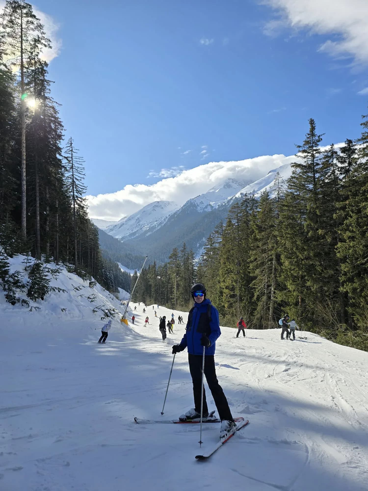 Stephan Koning op de besneeuwde pistes van Bansko, Bulgarije, met dennenbossen op de achtergrond