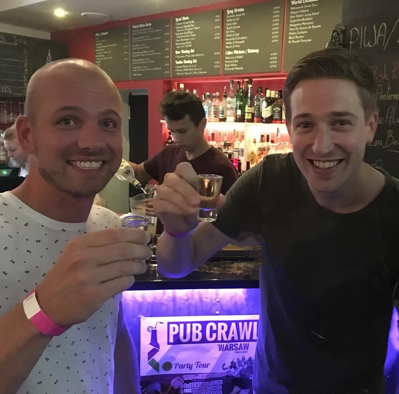 Stephan en vriend drinken een shotje tijdens de pub crawl in Warschau